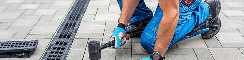 Drainlayer installing a channel drain in paving