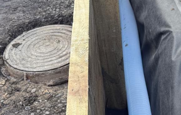 Manhole cover beside a newly installed drain run