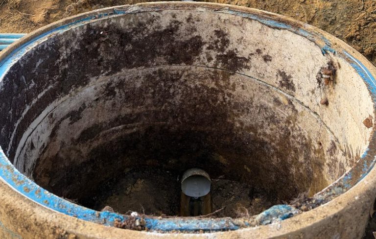 Inside of a large concrete sewer manhole during repairs