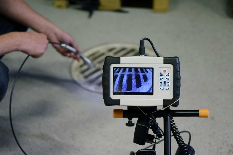 CCTV drain inspection camera monitor set up over a drain grate