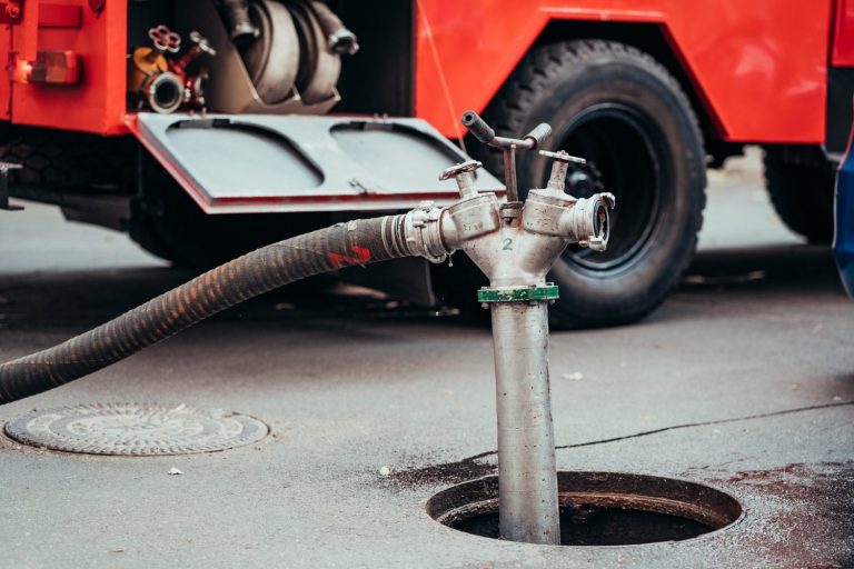 Drainage vacuum truck hose connected to a commercial drain