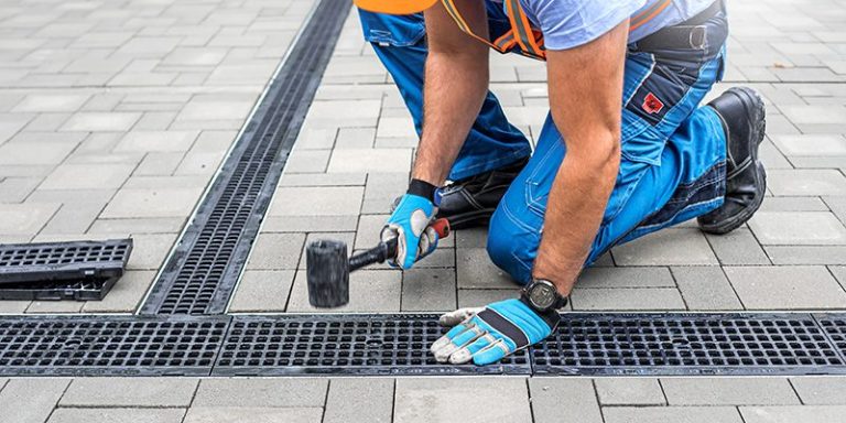Drainlayer installing a stormwater channel drain in paving